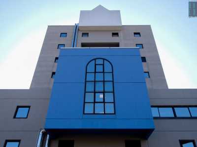 Pi� in basso vi � invece un corpo sporgente dal colore blu, con una finestra ad arco centrale, che spezza il grigiore e la verticalit� della facciata